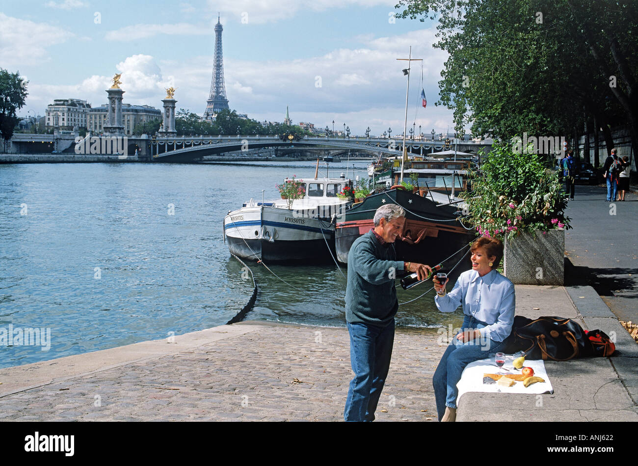 Paar mit Picknick am Ufer mit Eiffelturm Stockfoto