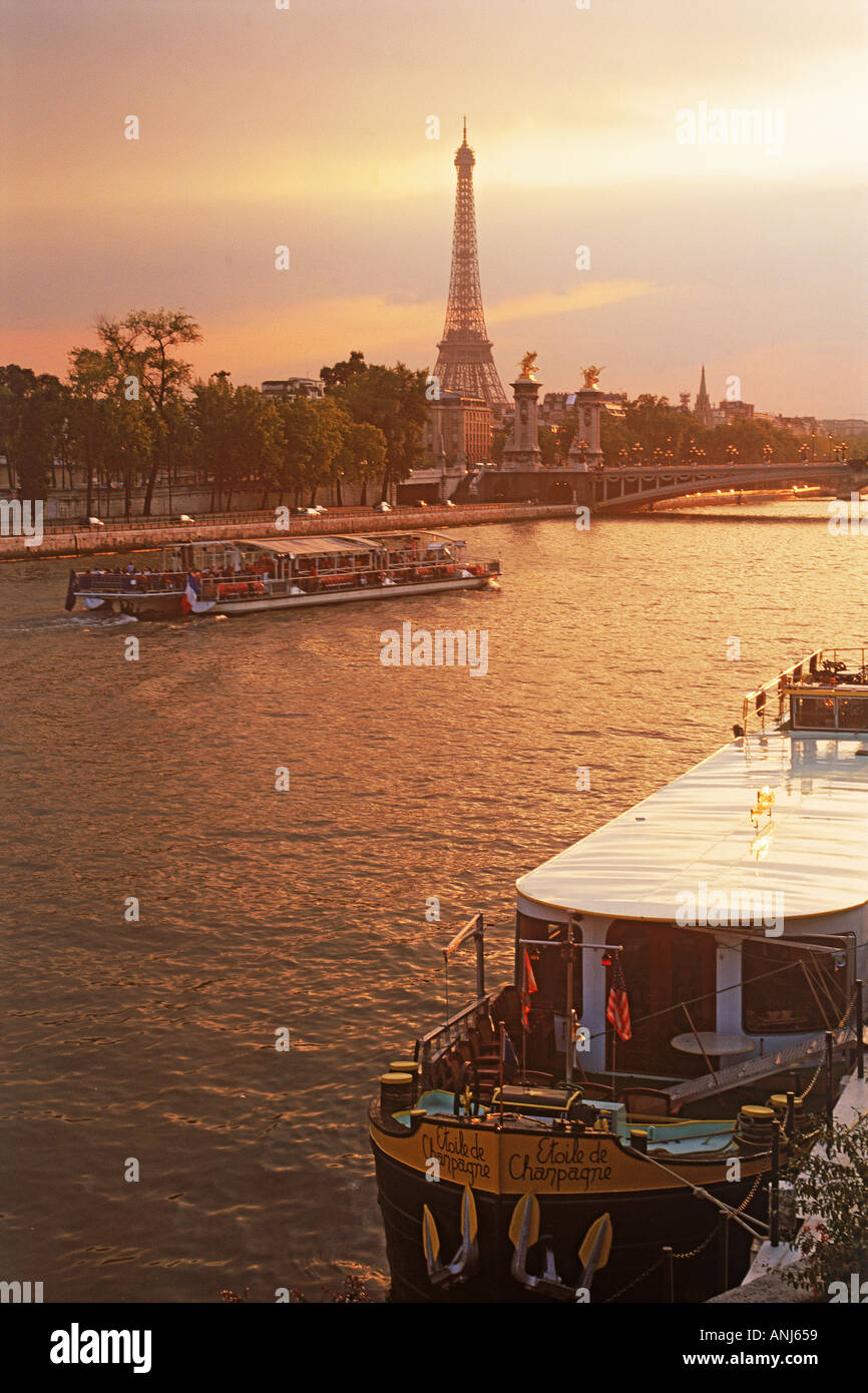 Ausflugsschiff und Hausboot am Ufer mit Eiffelturm Stockfoto