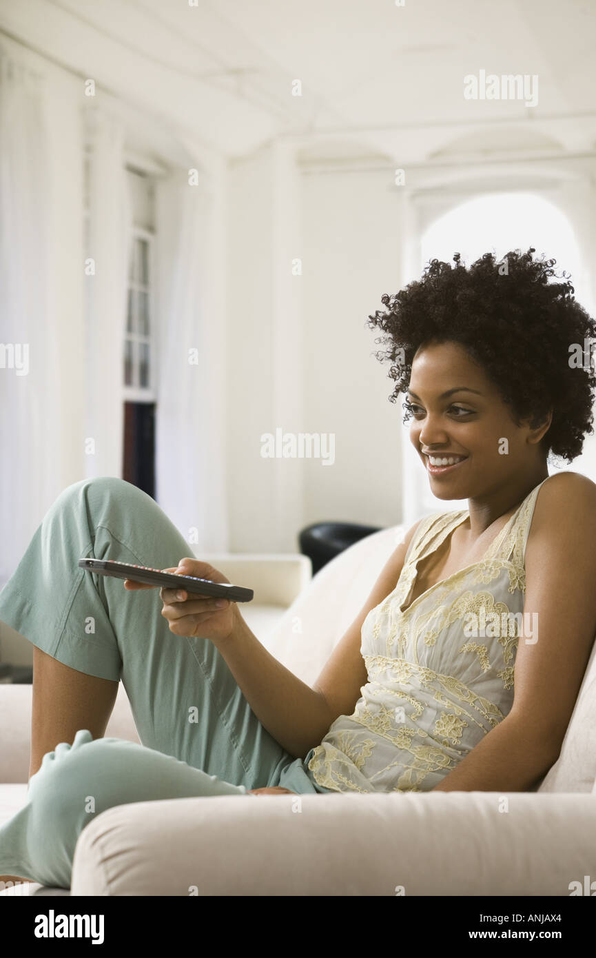 Junge Frau mit einer Fernbedienung Stockfoto