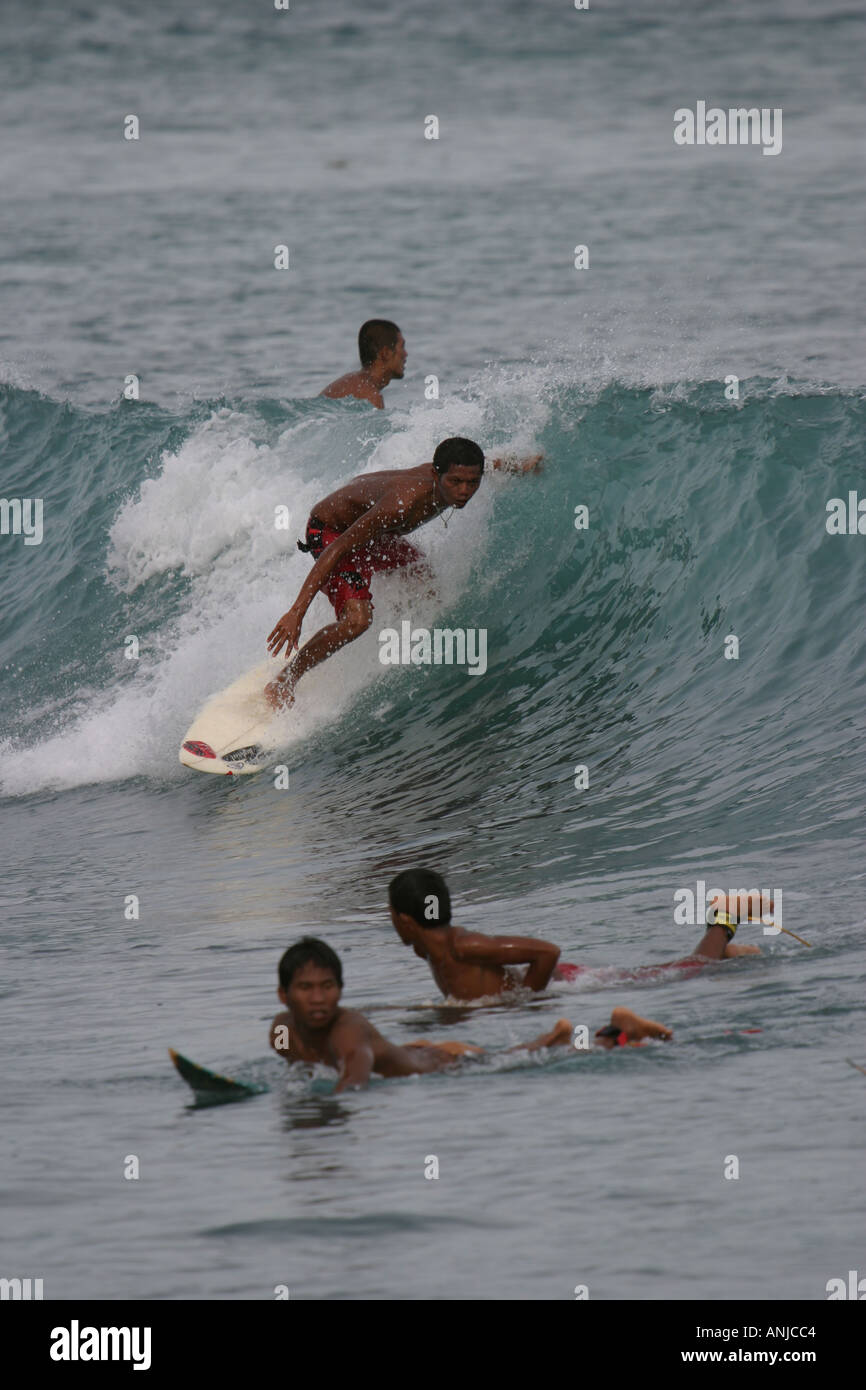indonesische Kinder beginnen zu surfen nehmen ernst, wie es ist das große Geld in für sie lustige kleine Jungs auf Wellen Stockfoto