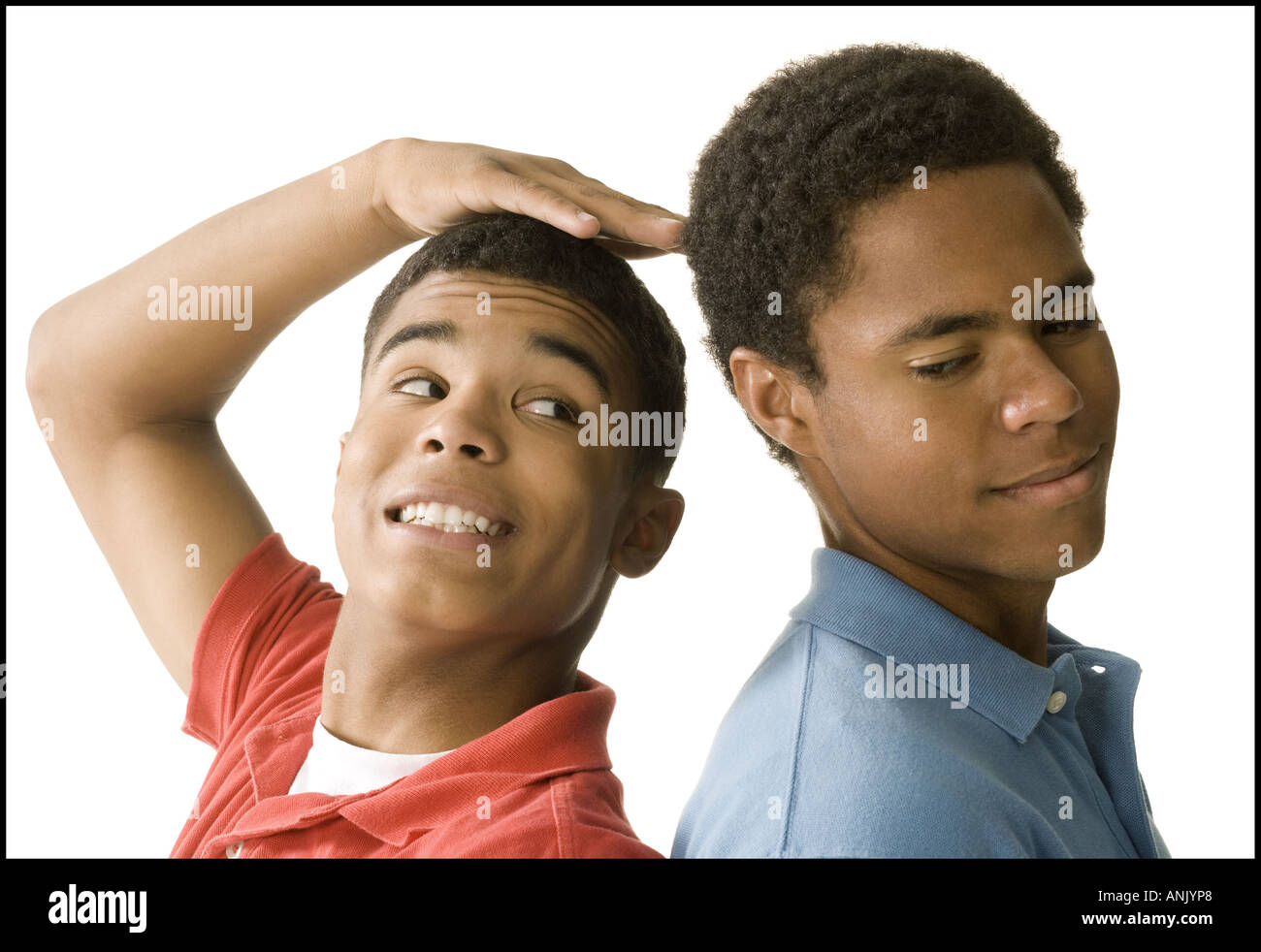 Nahaufnahme von zwei jungen Männern, die Rücken an Rücken stehend Stockfoto