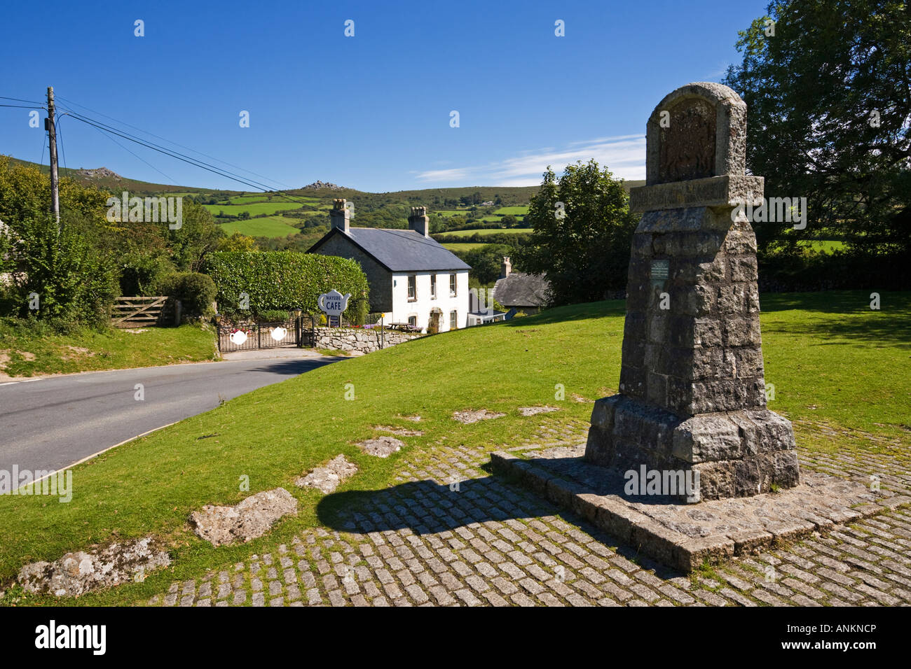 Widecombe in das Moor Ortsschild, Dartmoor, Devon, UK mit Bell Tor und Bonehill Felsen im Hintergrund Stockfoto