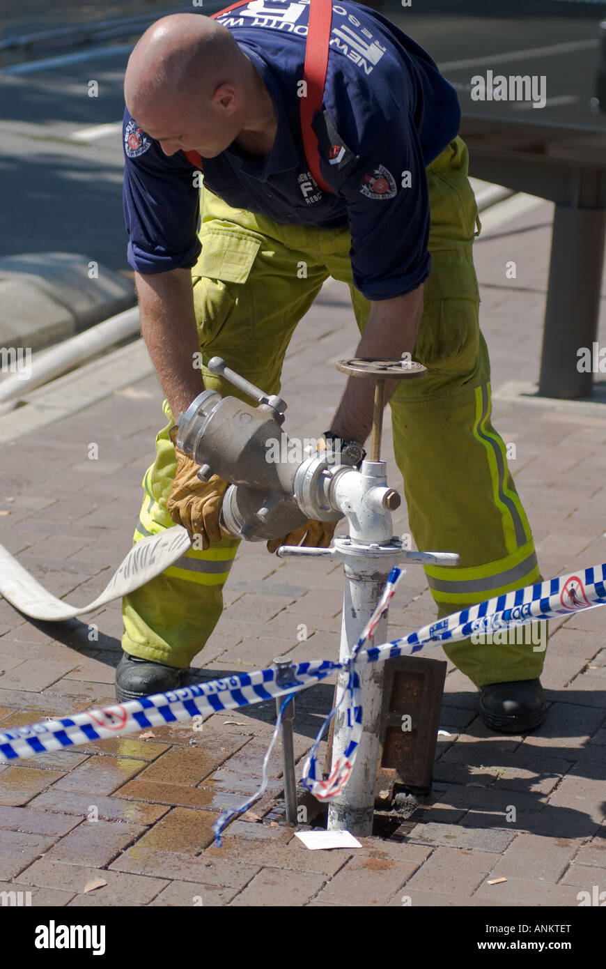 Feuerwehrleute am Arbeitsplatz Aufräumen nach einem Vorfall; Feuerwehrmann; Fire-Fighter; Schlauch um Feuer Hydrant anbringen; Stockfoto