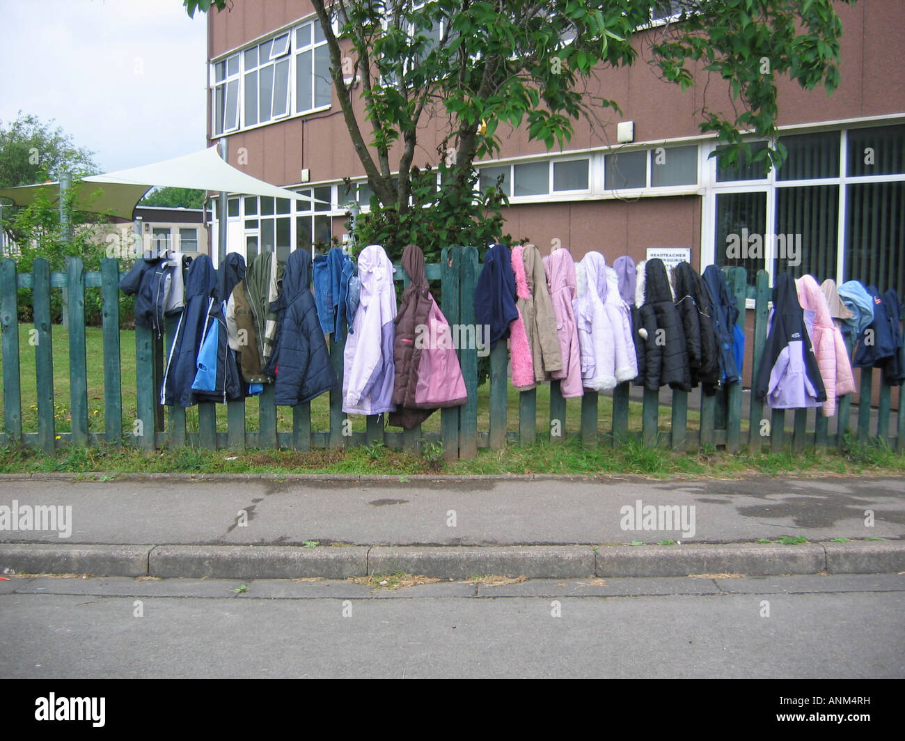 Schule für Kinder Mäntel auf Zaun in der Schule Stockfoto