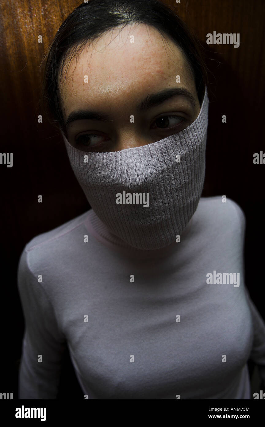 Mädchen mit Mund bedeckt durch ihren Rollkragen Pullover Stockfoto