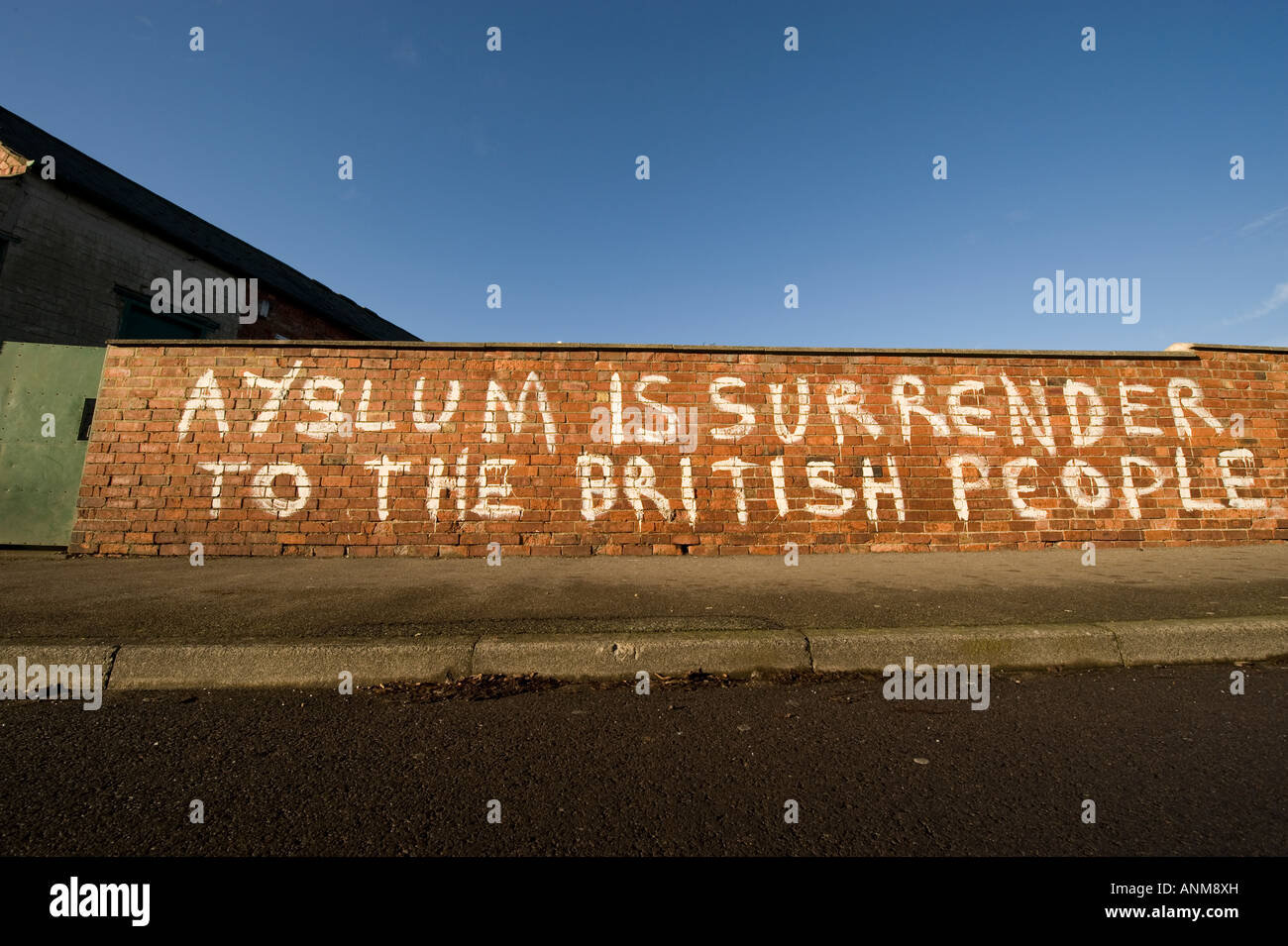 Ironisch rassistische Graffiti gegen Asylbewerber in Großbritannien Spray auf einer alten Mauer mit Rechtschreibfehler EDL Rassismus gemalt Stockfoto