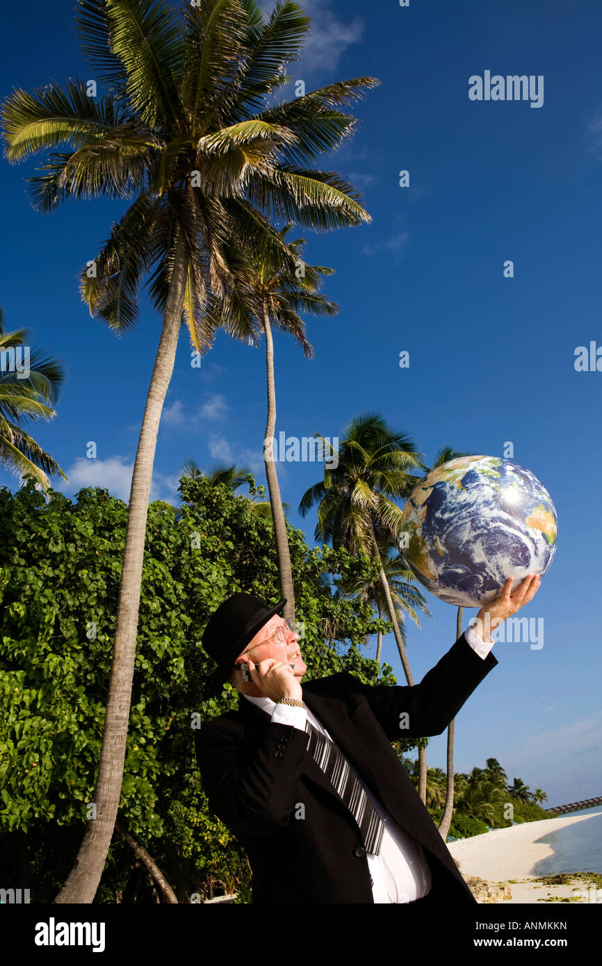 Malediven Geschäftsmann in Bowler-Hut und Business-Anzug mit Weltkugel in der Handfläche Stockfoto