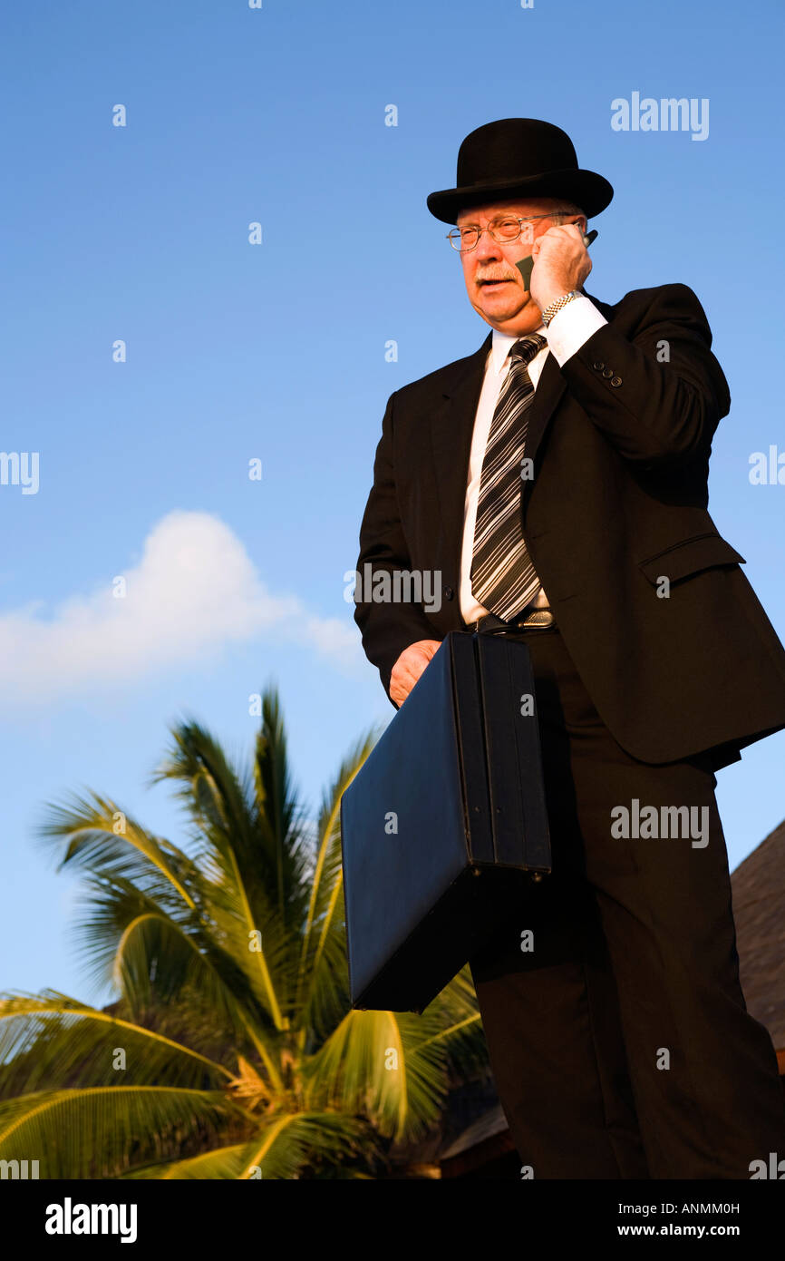 Malediven Workaholic Geschäftsmann in Melone und Business Anzug telefonieren mit Handy tropischen Weg Stockfoto
