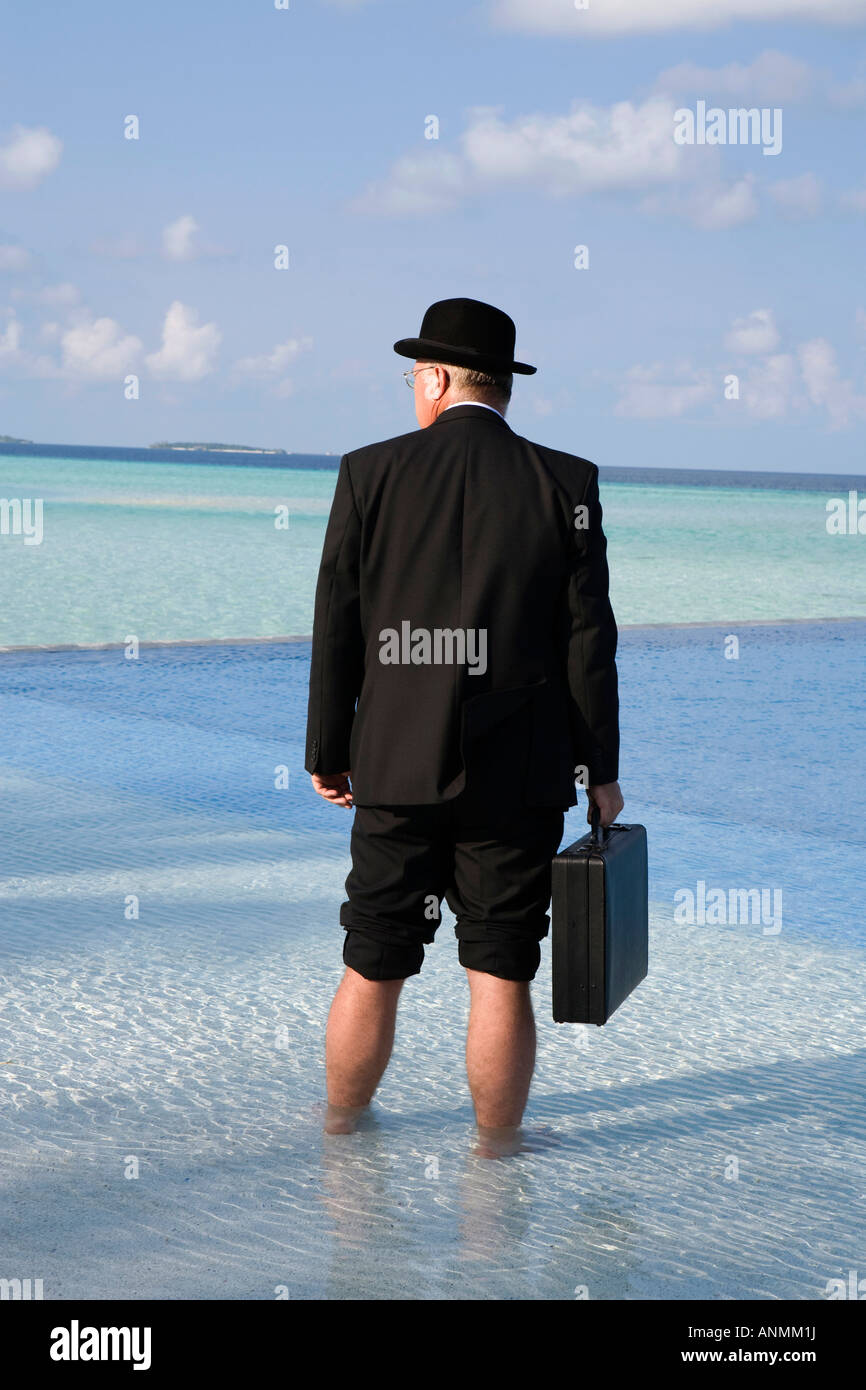 Malediven, Überhitzung, westliche Geschäftsmann in Melone gekleidet und Business-Anzug stand im Schwimmbad Stockfoto