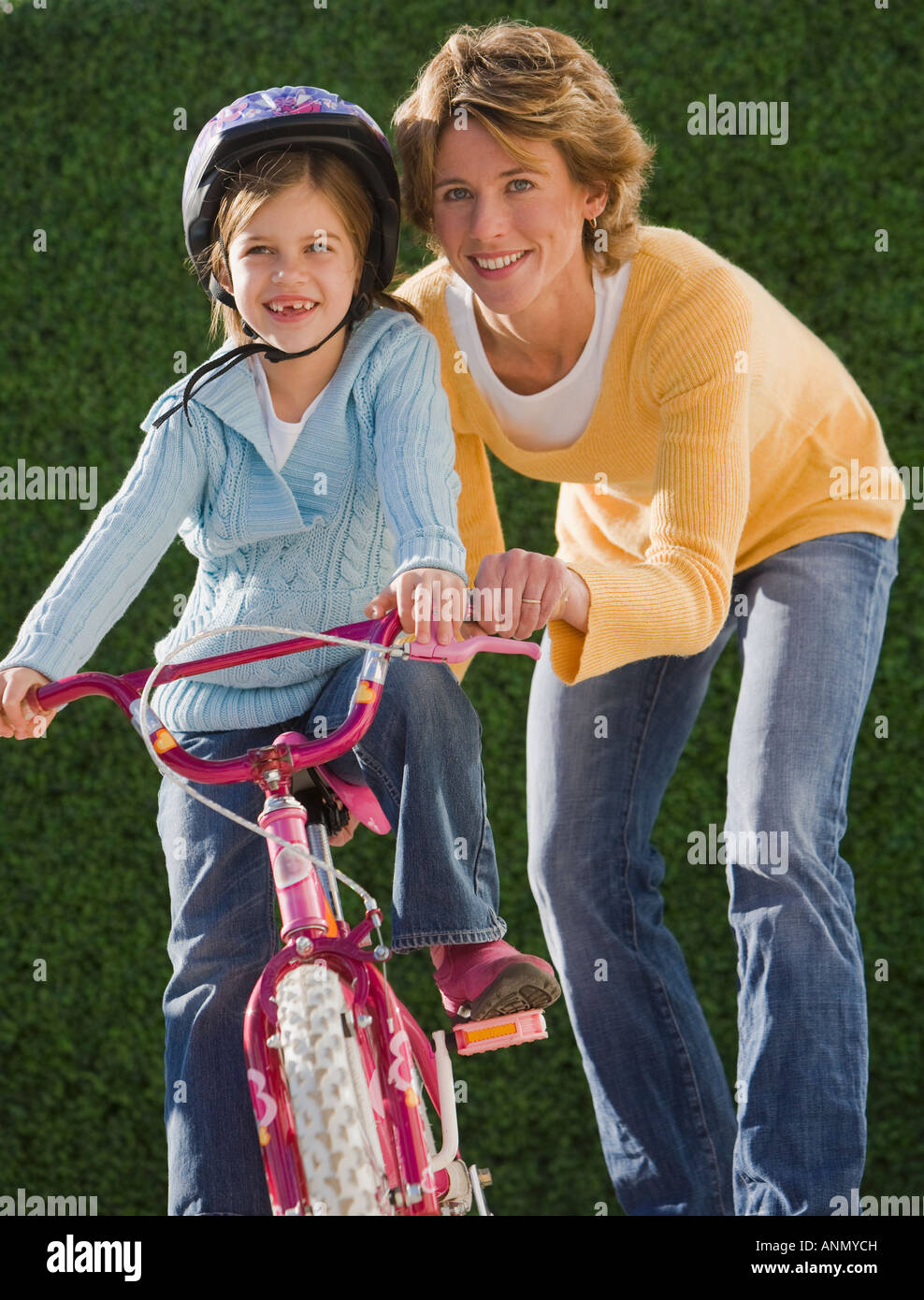 Mutter Tochter Fahrt Fahrrad helfen Stockfoto