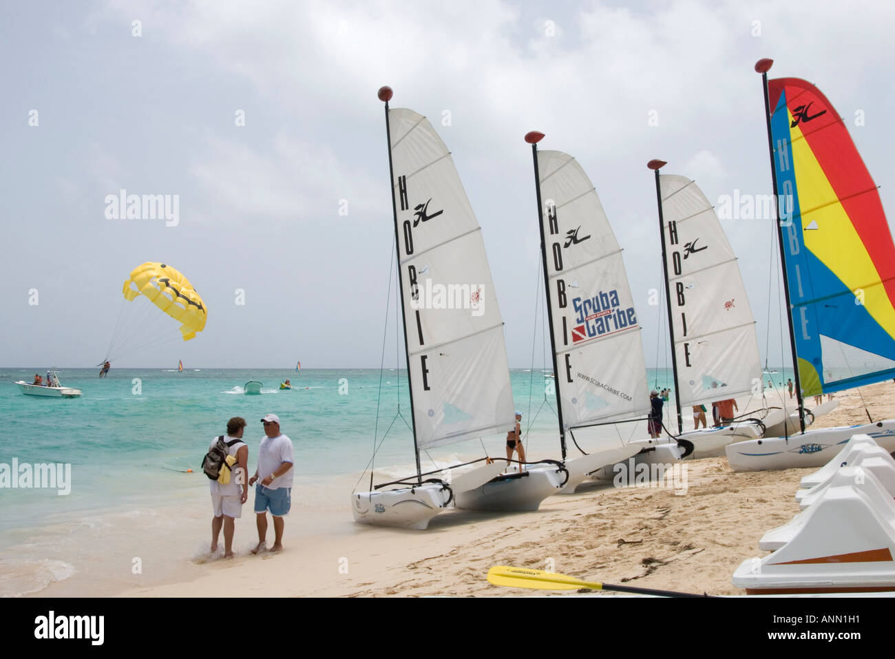 Urlauber am Strand mit Katamaranen und Parasailer in Punta Cana, Dominikanische Republik, August 2006 Stockfoto