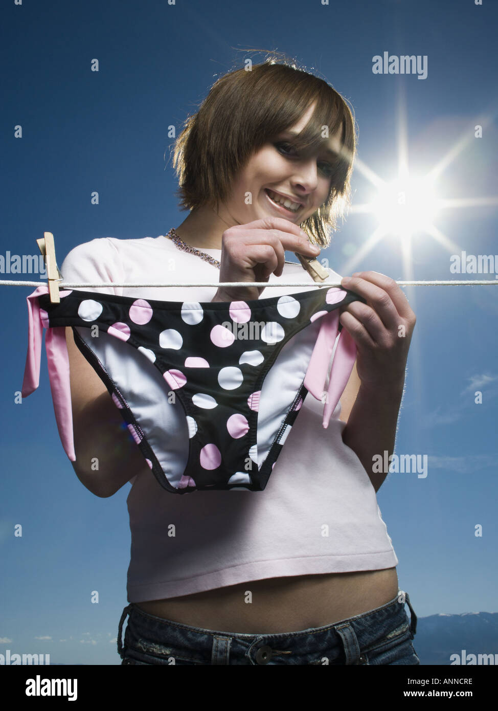 Niedrigen Winkel Ansicht eines Mädchens ein Bikiniunterteil auf einer Wäscheleine trocknen Stockfoto