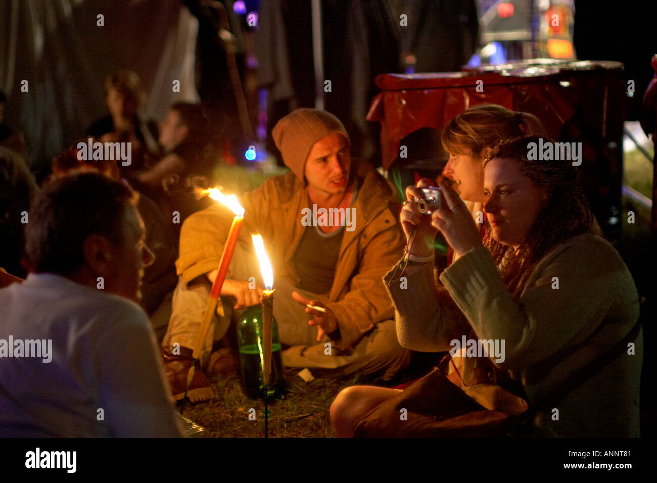 Leute sitzen, plaudern und Rauchen in der Nacht bei Glastonbury Festival für zeitgenössische darstellende Kunst Somerset England UK 2005 Stockfoto