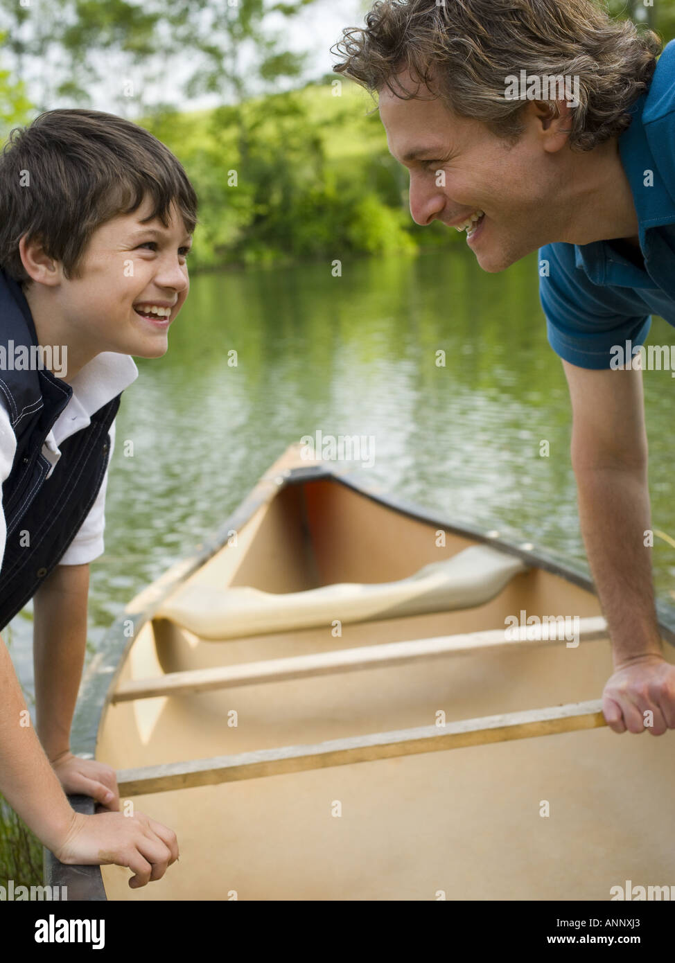 Profil von einem Mann und seinem Sohn ein Kanu nach vorn bücken Stockfoto