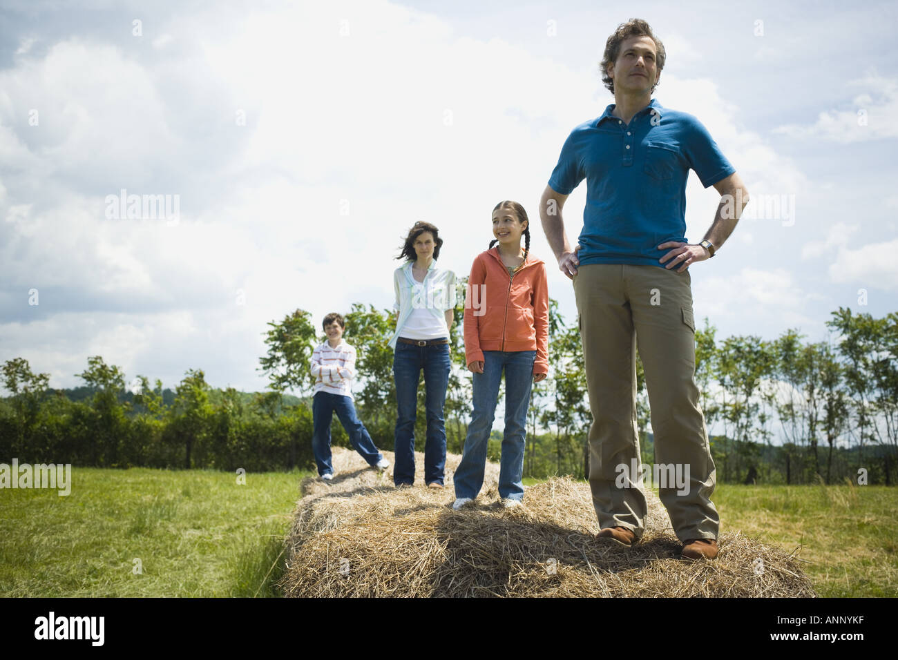 Mann und eine Frau, die mit ihren Kindern auf Heuballen Stockfoto