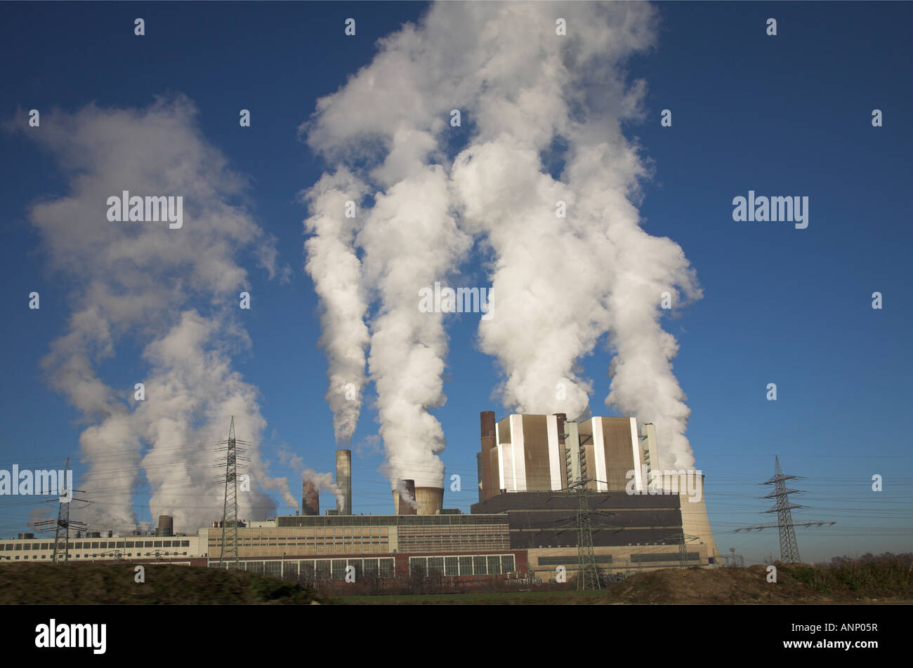 Powerstation Kühltürme emittierende Dampf in einem blauen Winterhimmel. Stockfoto