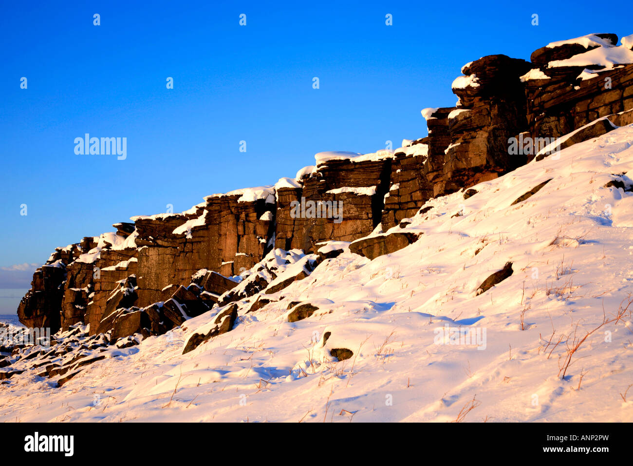 Späten Winter Sonnenuntergang auf einem verschneiten Stanage Edge Peak District National Park Derbyshire England Großbritannien UK Stockfoto