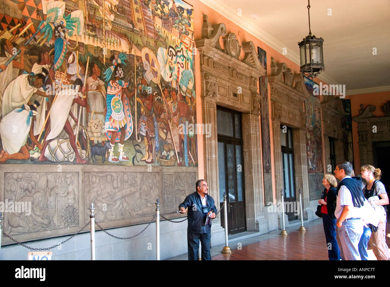 Ein Reiseleiter zeigt Touristen ein Wandgemälde von Diego Rivera im National Palace in Mexiko-Stadt Mexiko Stockfoto