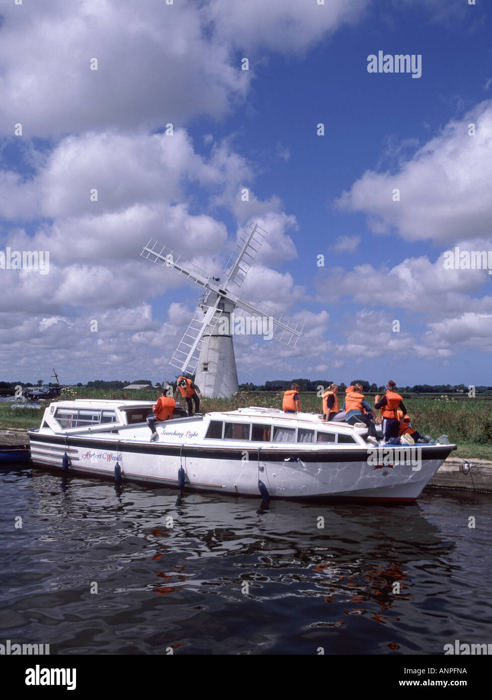Gruppe von jungen Mädchen Teenager & minder auf einem gepanzerten Kabinenkreuzer, der eine hohe Vis-orangefarbene Lebensjacke an der Thurne Dyke Windpumpe auf Norfolk Broads England UK trägt Stockfoto
