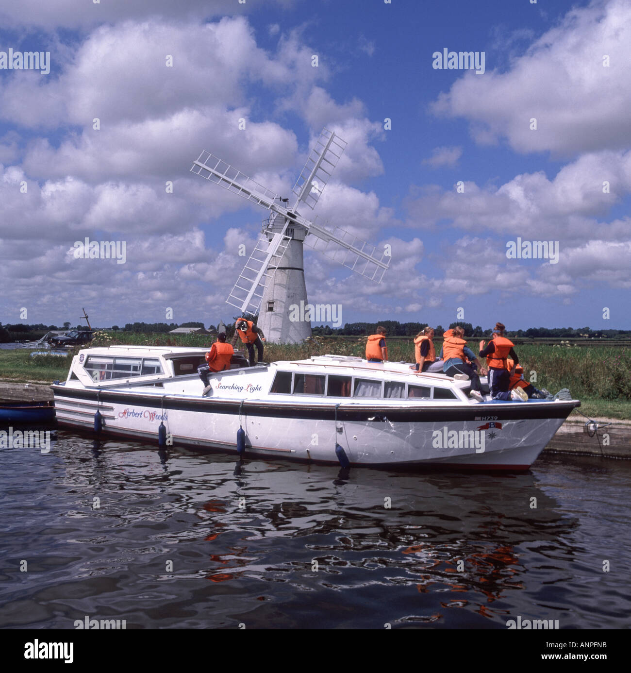 Gruppe von jungen Mädchen Teenager & minder auf einem gepanzerten Kabinenkreuzer, der eine hohe Vis-orangefarbene Lebensjacke an der Thurne Dyke Windpumpe auf Norfolk Broads England UK trägt Stockfoto