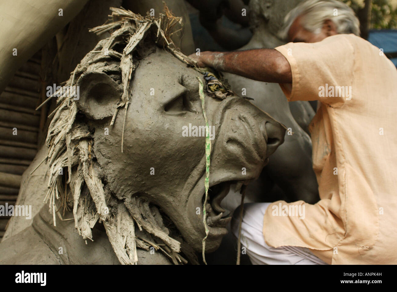 Ein Bildhauer schafft ein Löwe aus Stroh und Lehm in der Kumartuli sind von Kolkata, Indien. Stockfoto