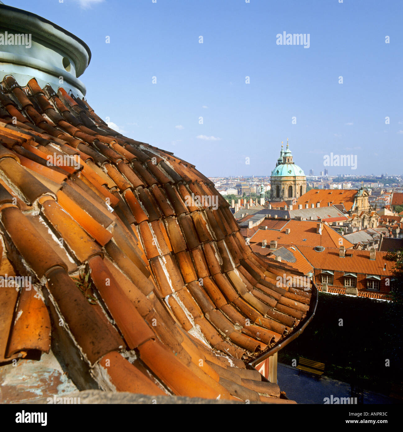 Verwitterten Sie alten Terrakottafliesen Dach, Rahmen Blick auf Kirche und Zentrum von Prag auf einem klaren sonnigen Tag Tschechien Stockfoto