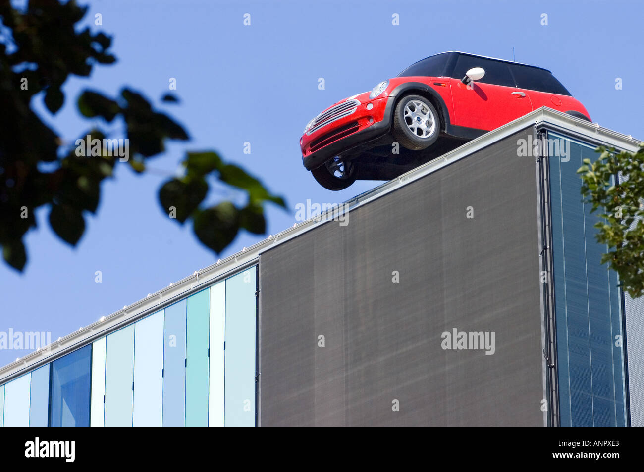 Oh Hoppla Hoppla rotes Auto MINI Parkplatz auf einem Dach Humor lustig lustig albern Stockfoto