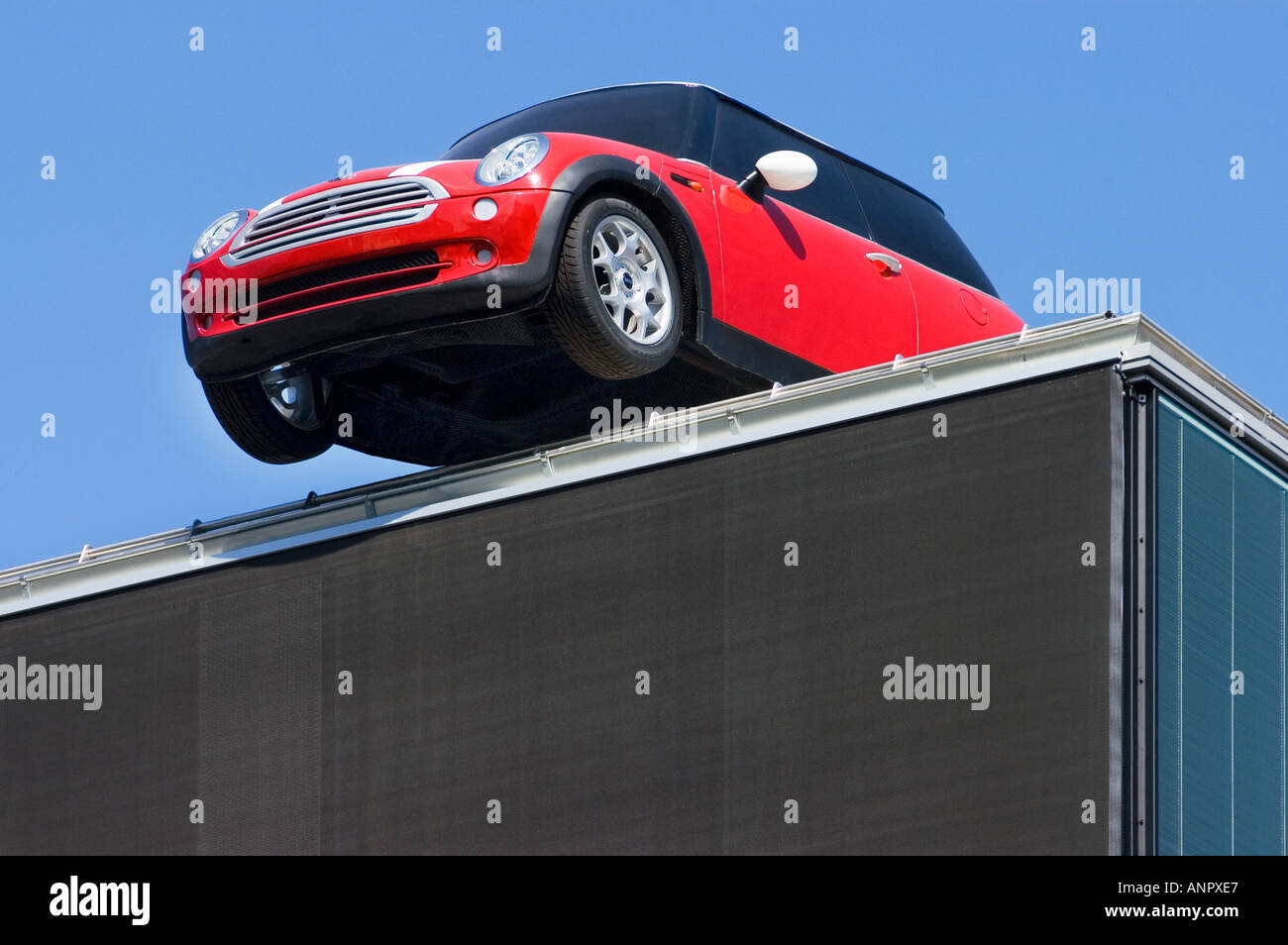 Oh Hoppla Hoppla rotes Auto MINI Parkplatz auf einem Dach Humor lustig lustig albern Stockfoto