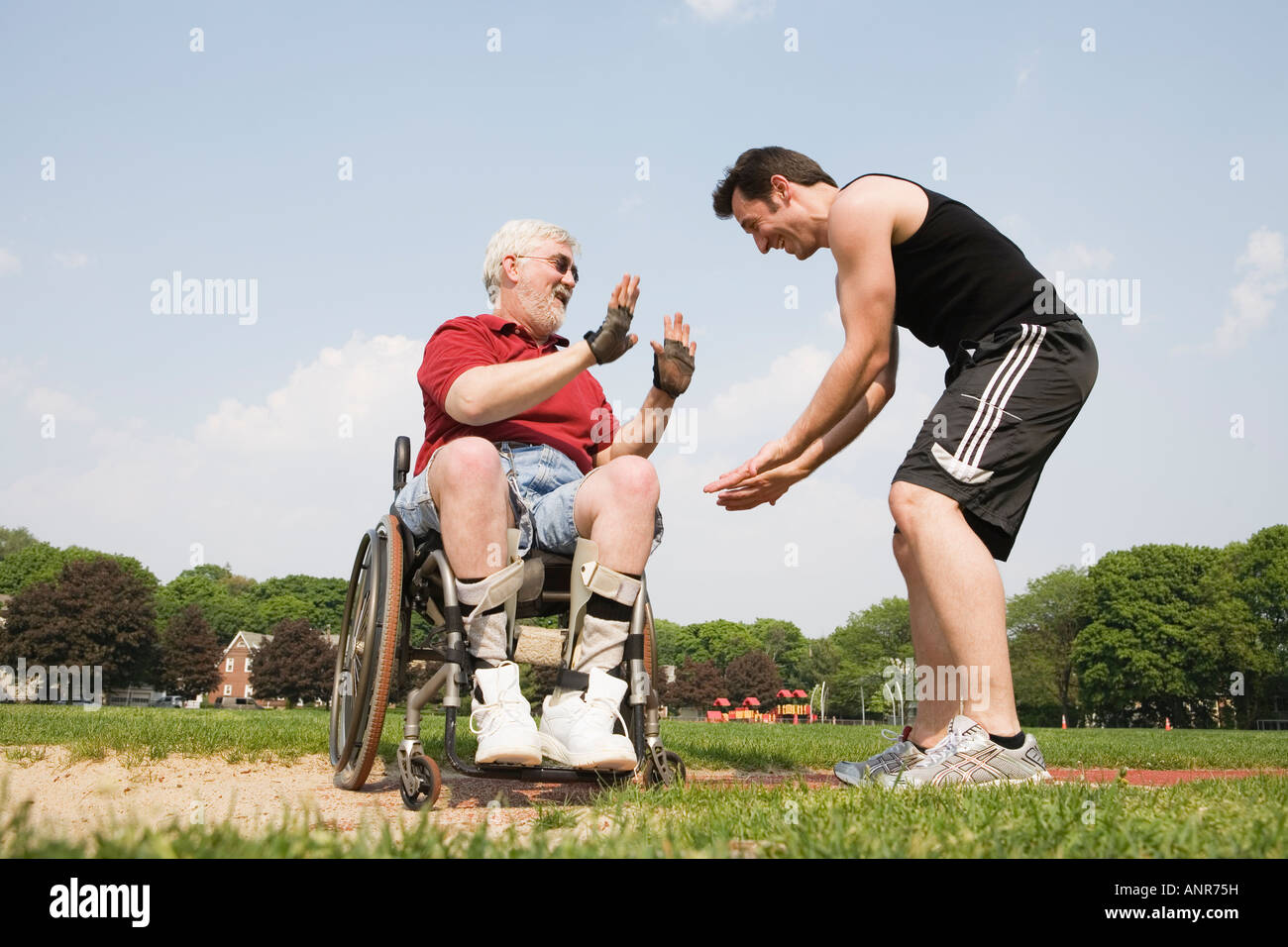 Junger Mann mit einem behinderten älteren Mann gestikulieren. Stockfoto