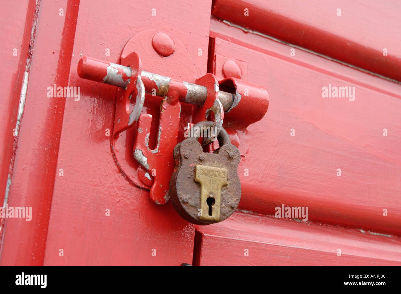 Vorhängeschloss und Hasp und Grundnahrungsmittel, rot gemalte Hütte Tür zu sichern Stockfoto