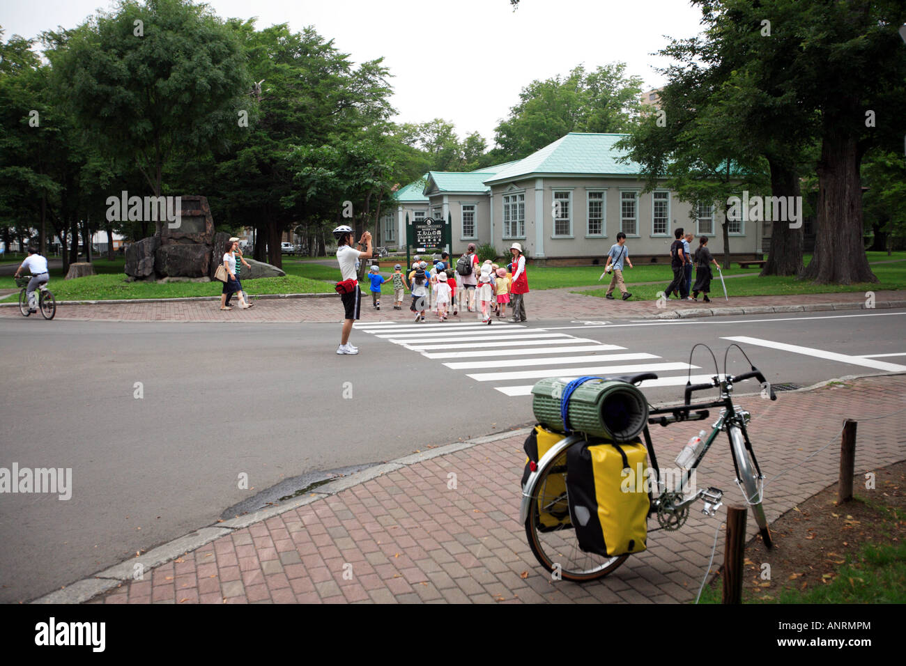 Kindergartenkinder spielen am Campus der Hokkaido Universität Sapporo Japan Fahrrad geparkt im Vordergrund Stockfoto