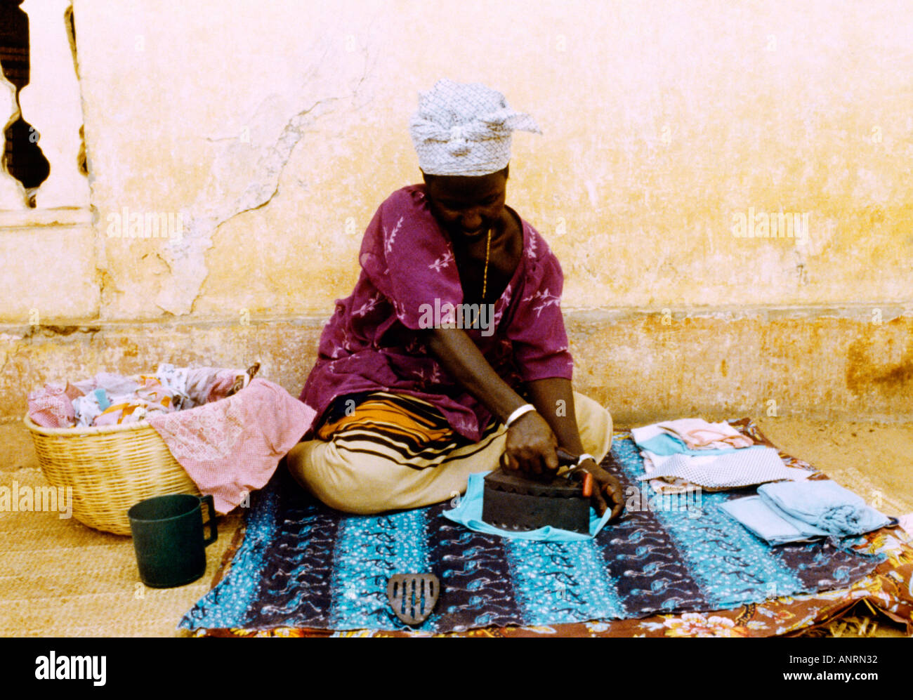 Dakar Senegal Frau Bügeln auf Boden Stockfoto