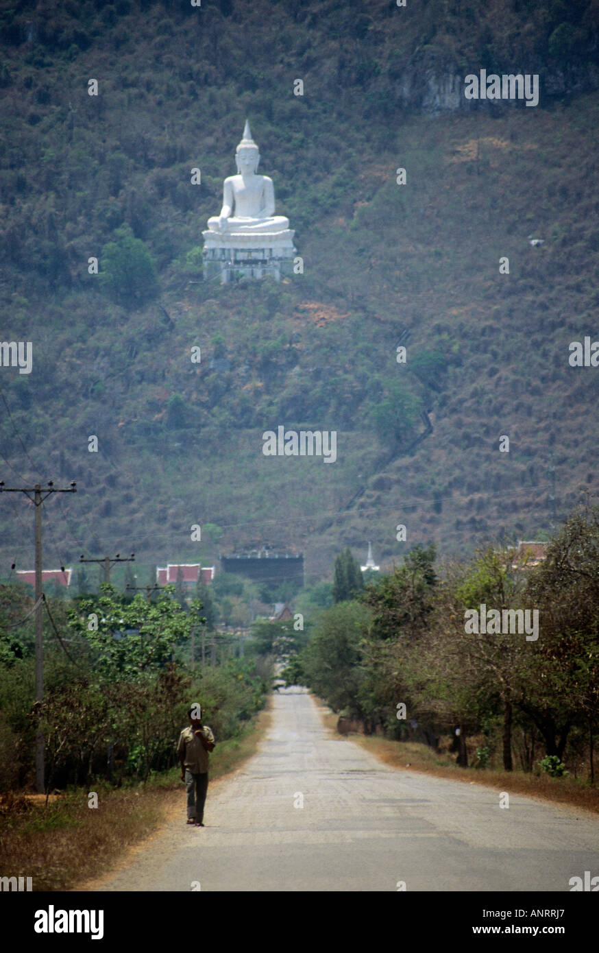 Eine weiße steinerne Statue eines Bildes des Buddha festlegen auf einem bewaldeten Hügel in der Nähe der Straße, die führt zu Pak Chom Stockfoto