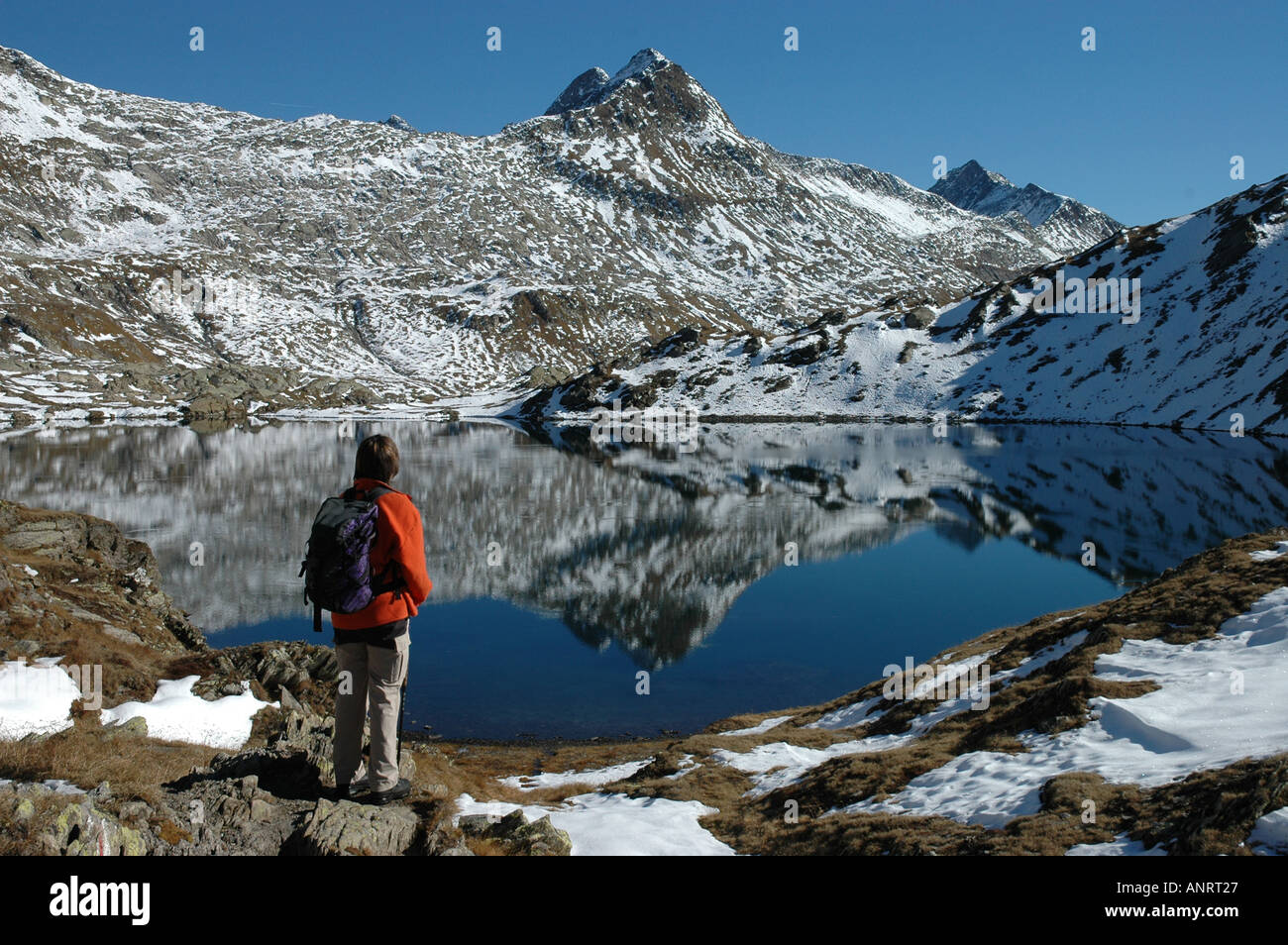 Wanderer-weiblich am See Lago di Dentro Cadlimo Piz Tanelin Reflexion Herbst Schnee Tessin Tessiner Alpen Schweiz Stockfoto