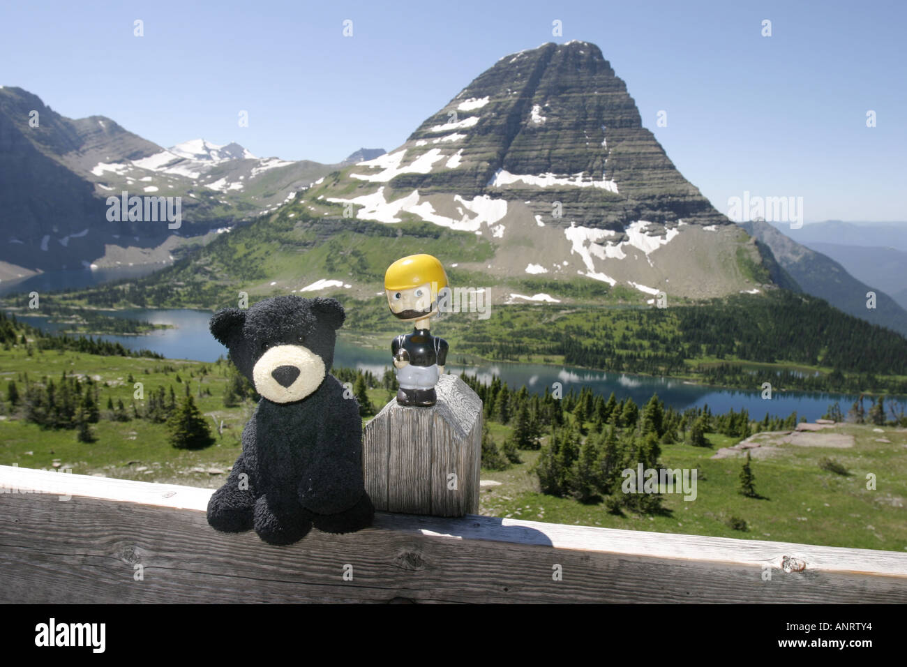 Eine Puppe und sein Teddybär-Freund auf den Hidden Lake über-Blick im Glacier National Park, Montana. Bearhat Berg im Hintergrund Stockfoto