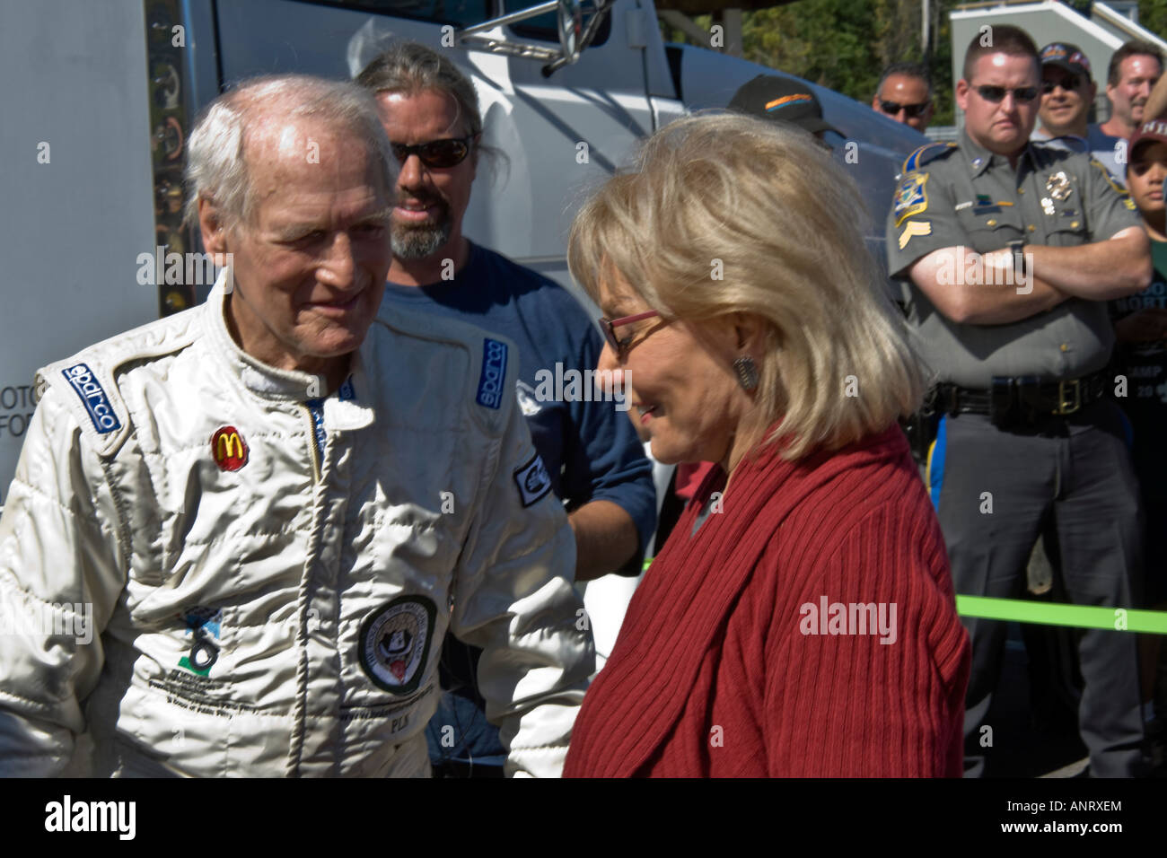 Paul Newman spricht und lacht mit Barbara Walters mit mürrischen Polizisten geschützt Stockfoto
