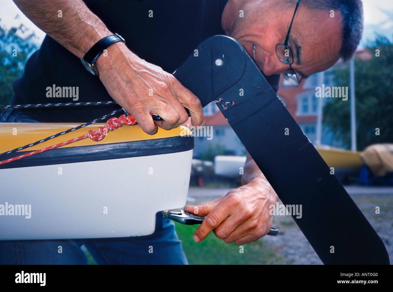Ein Mann repariert Ruder auf einem Seekajak. Stockfoto
