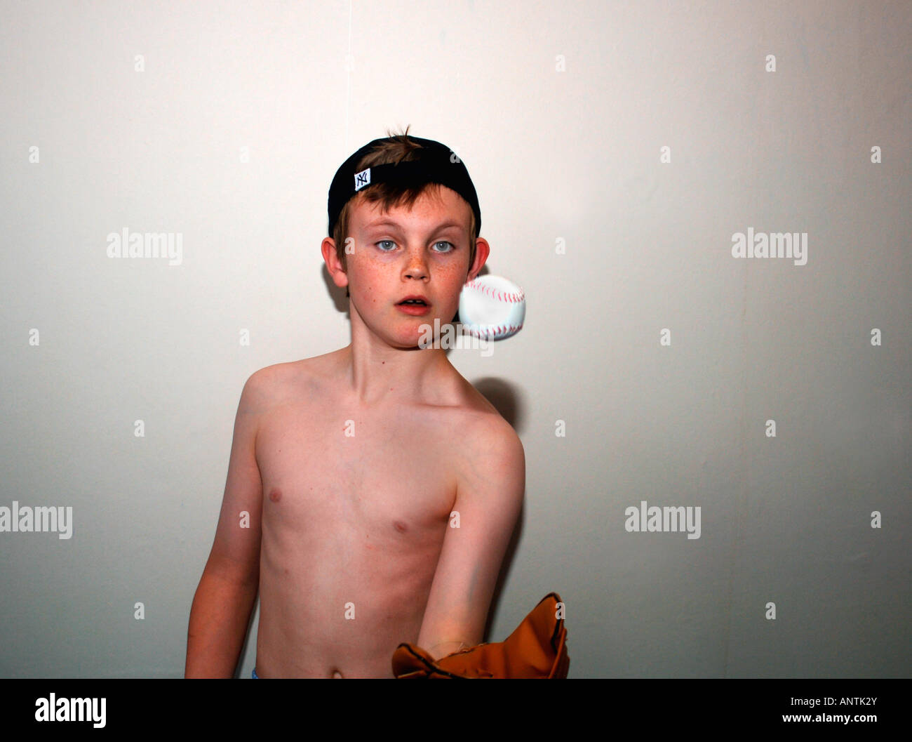 Ein B&W Bild von einem 13 Jahre alten Jungen tragen eine Baseball-Cap & Mitt, fangen mit einem Baseballschläger In seinem Schlafzimmer spielen. Stockfoto