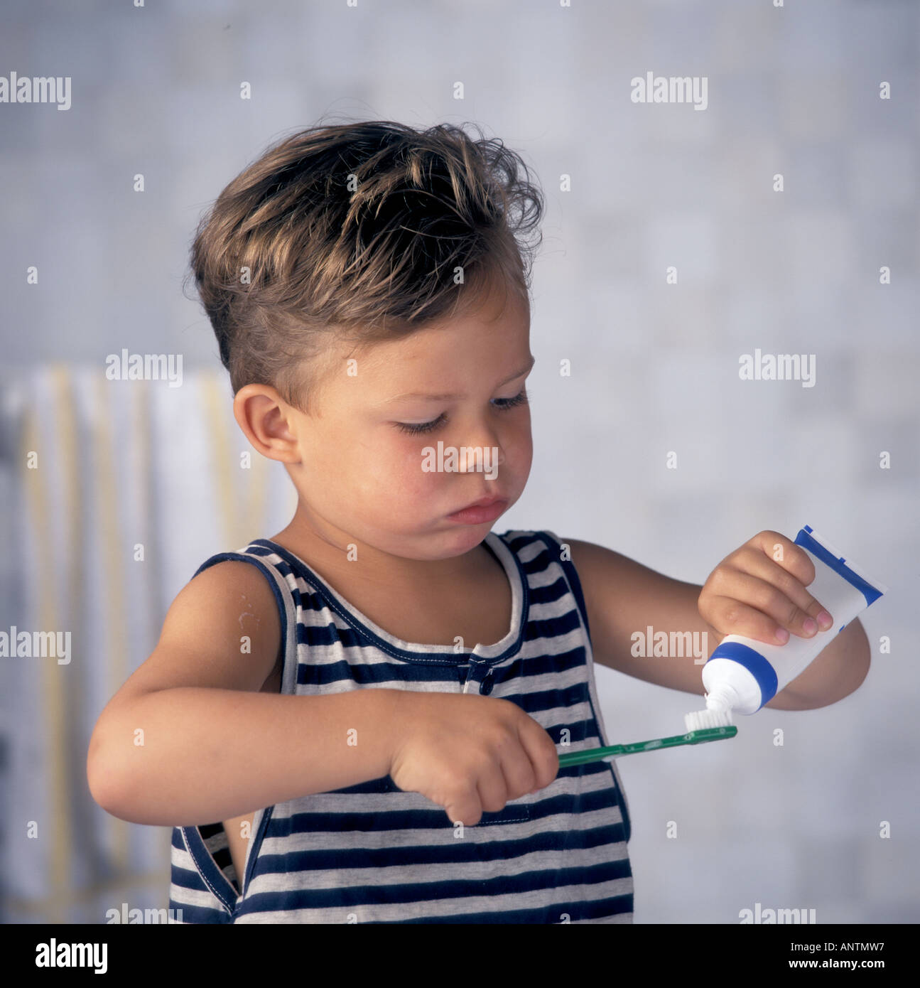 Kleiner Junge setzt auf seine Zahnbürste Zahnpasta Stockfoto