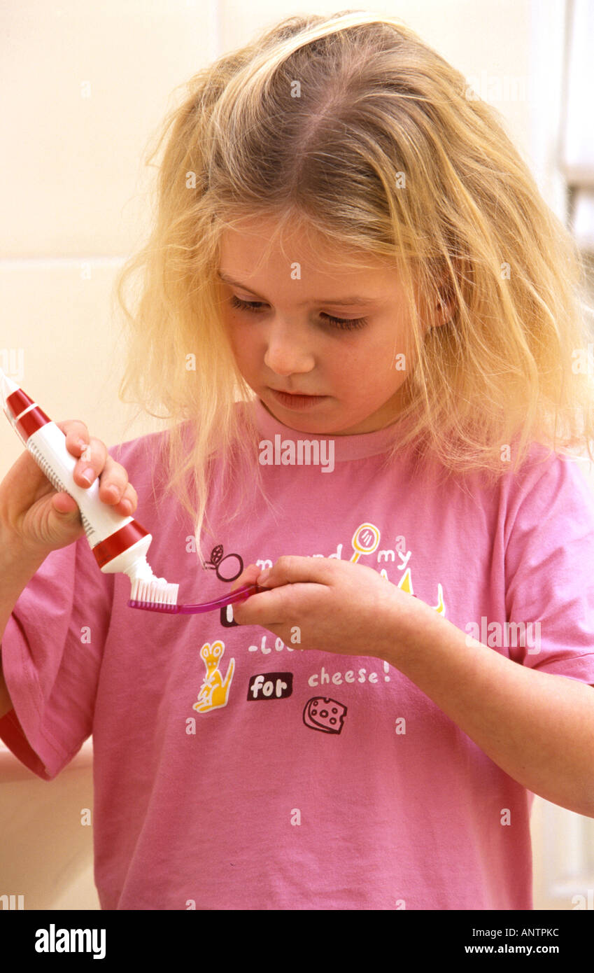 Kleines Mädchen setzt die Zahnpasta auf ihre Zahnbürste Stockfoto