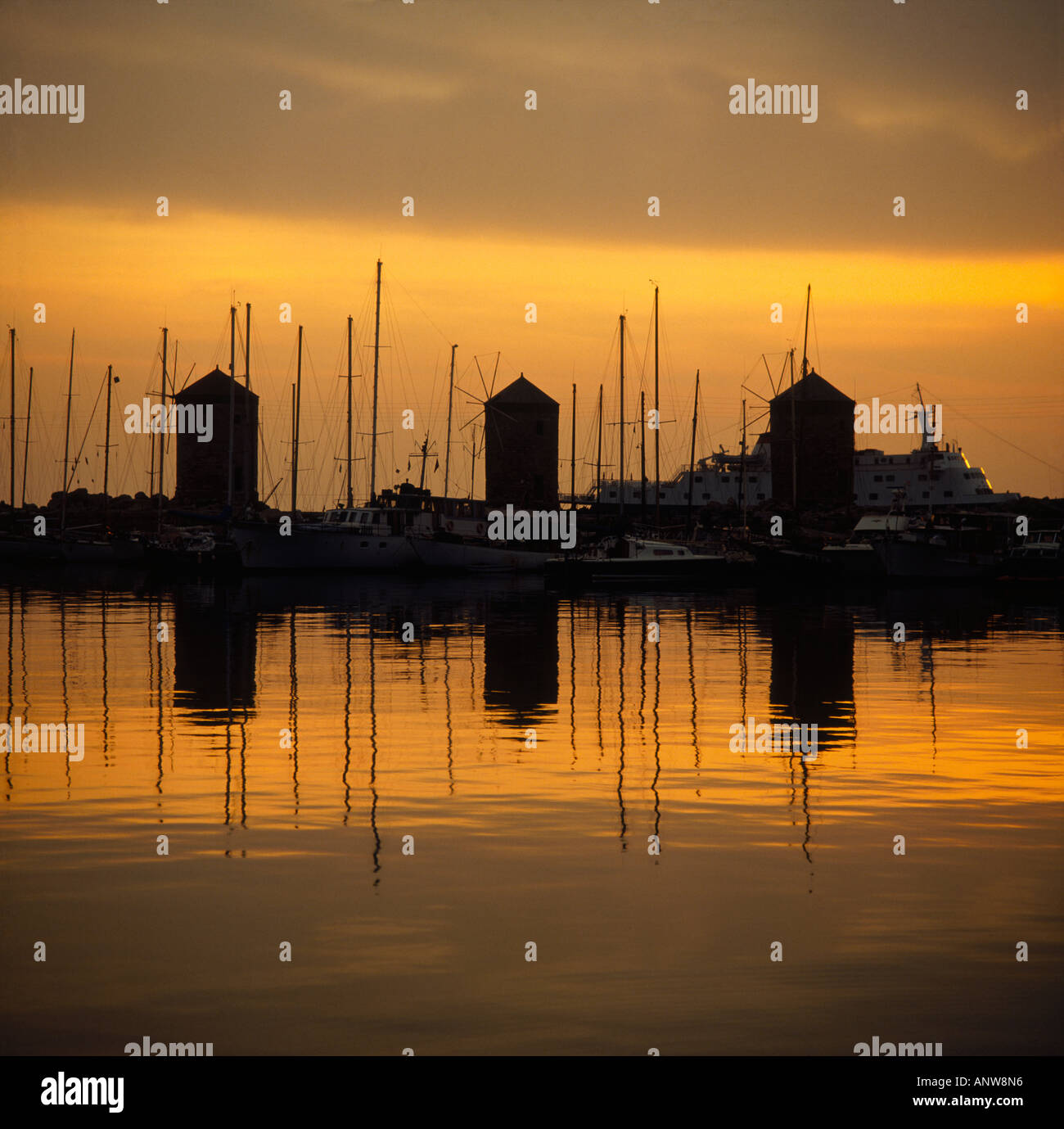 Dawn Blick auf Segelbooten und Yachten vor der Silhouette der drei alten Windmühlen am Mandraki Hafen Rhodos griechische Inseln Stockfoto