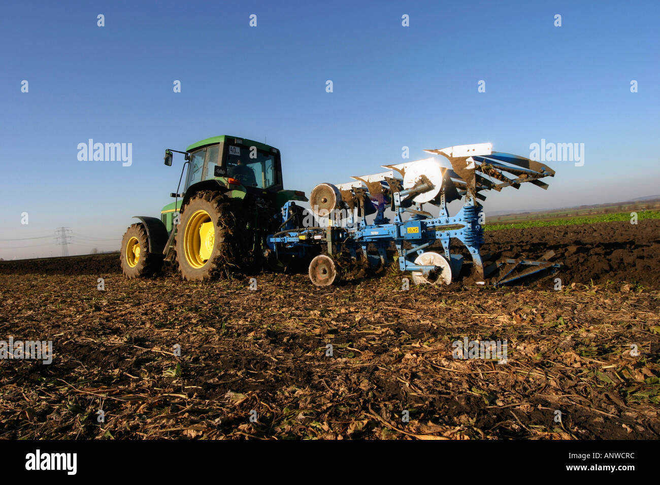 Traktor mit Pflug in einem Feld Stockfoto