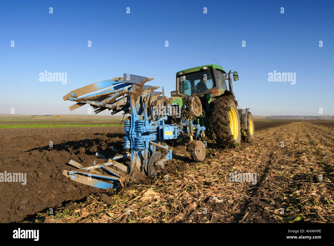 Traktor mit Pflug in einem Feld Stockfoto