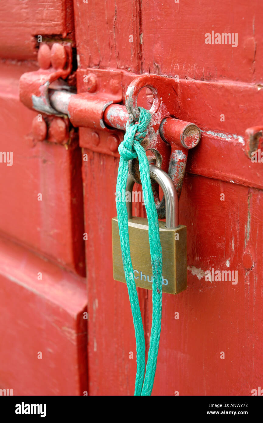 Vorhängeschloss und Hasp und Grundnahrungsmittel, rot gemalte Hütte Tür zu sichern Stockfoto