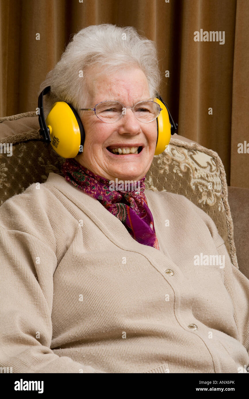 Ältere Dame tragen Ohr ^ Verteidiger und lachen Stockfoto