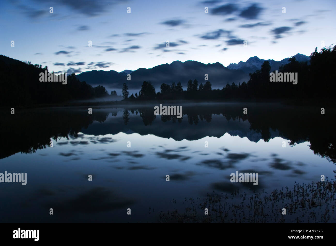 Neuseeland, Südinsel. Lake Matheson nachts reflektieren ein in der Nähe von perfektes Bild von Mt Tasman und Aoraki Mount Cook (3754m). Stockfoto