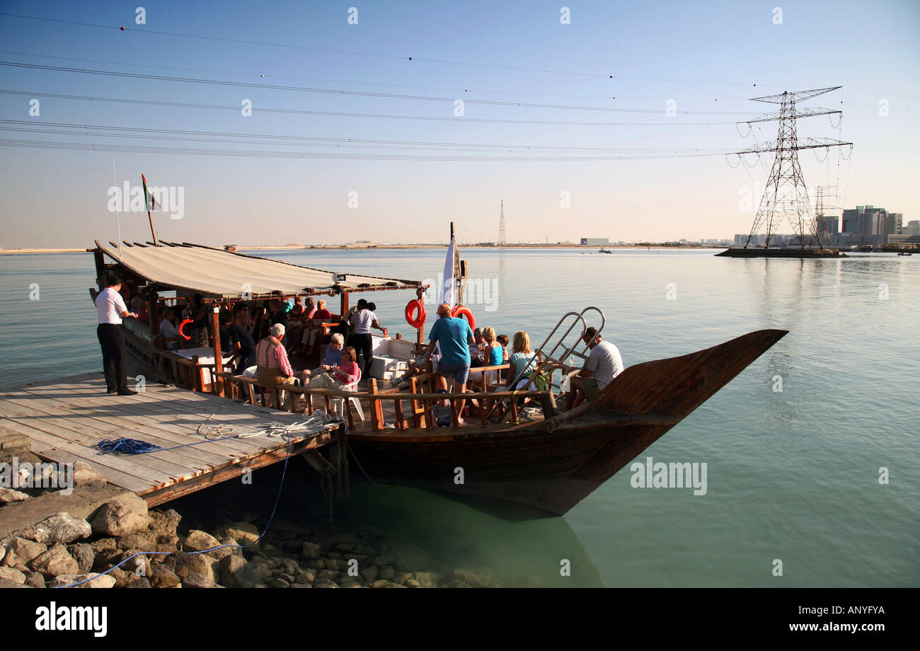 Einer traditionellen hölzernen Dhau vor Anker und Übernahme von Passagieren für eine schwimmende Party, Abu Dhabi, Vereinigte Arabische Emirate Stockfoto