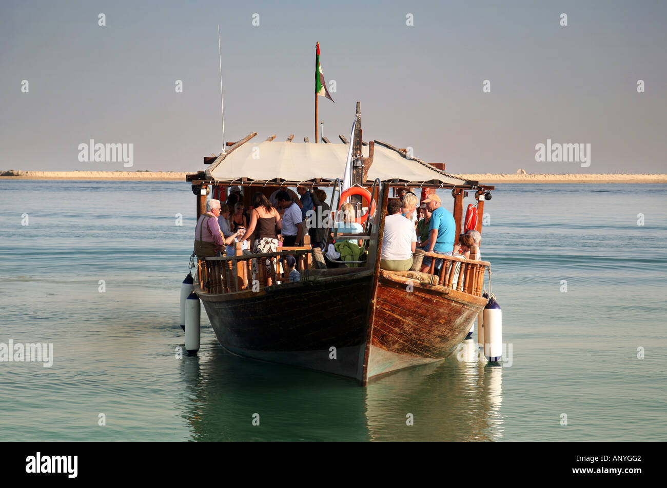 Vorderansicht von einer traditionellen hölzernen Dhau flott mit einer Gruppe von Touristen an Bord, Abu Dhabi, Vereinigte Arabische Emirate Stockfoto