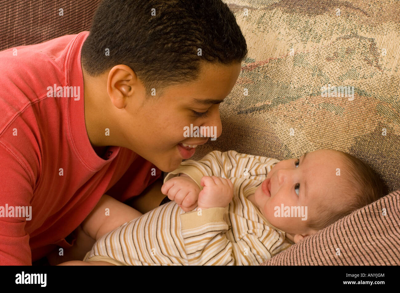 3 Monate altes Baby Boy Interaktion mit 15-jähriger Teenager halb Bruder horizontale Hispanic Puerto Rico Stockfoto