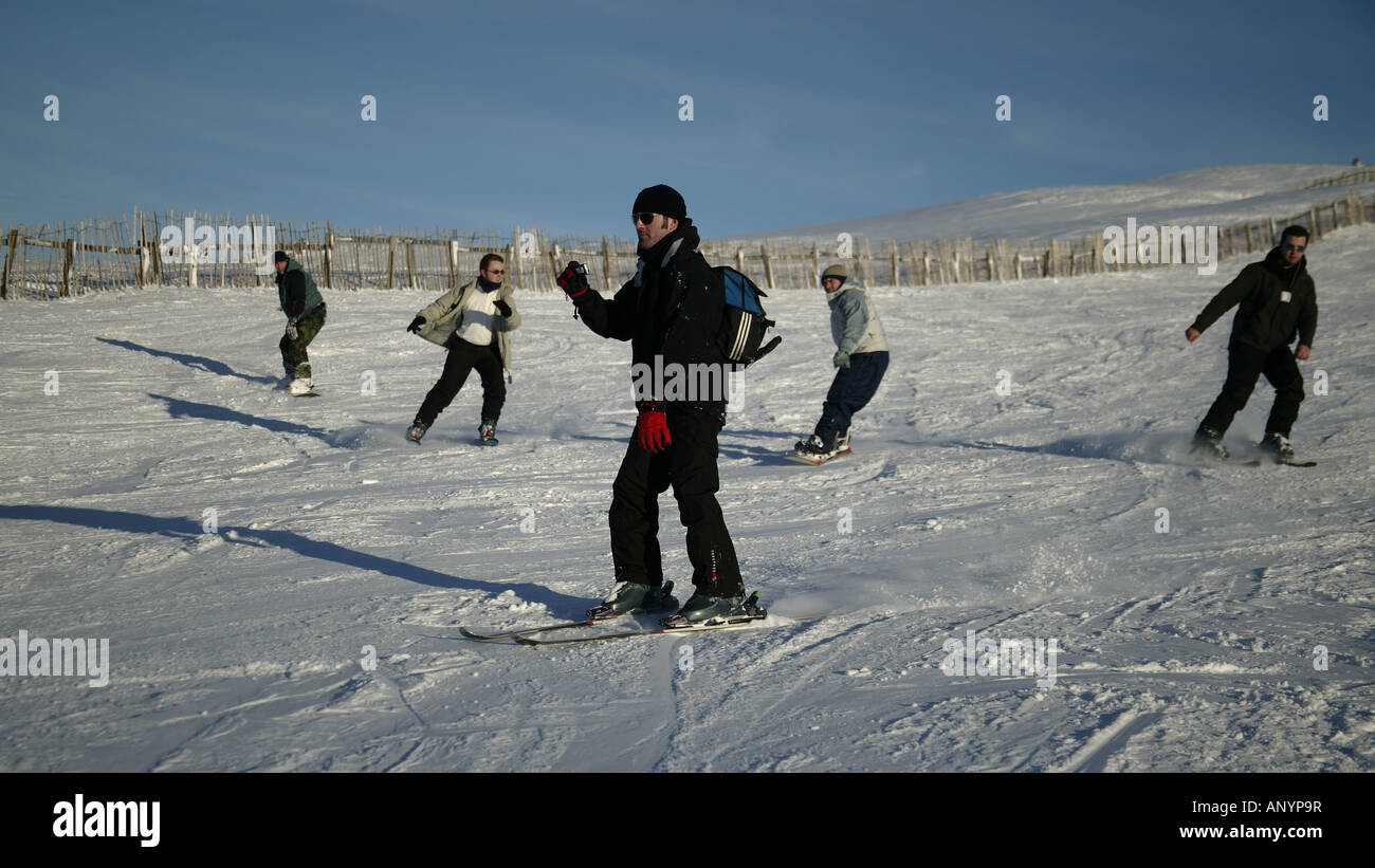 Fünf Männer Skifahren und Snowboarden, Cairngorms National Park, Glenshee, Perthshire und Aberdeenshire, Schottland, UK, Europ. Stockfoto